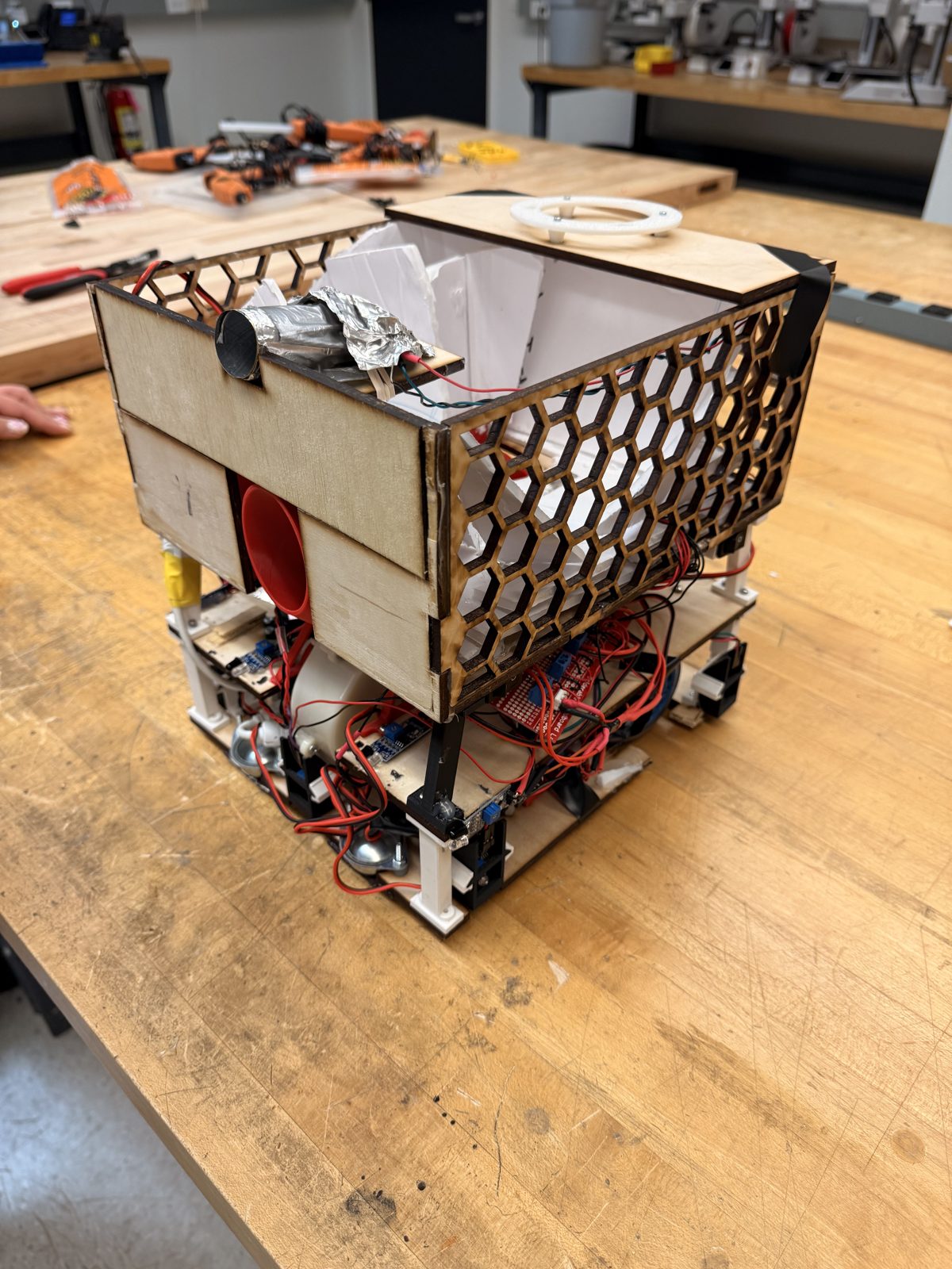 Laser cut mechatronics robot with honeycomb paneling on workbench